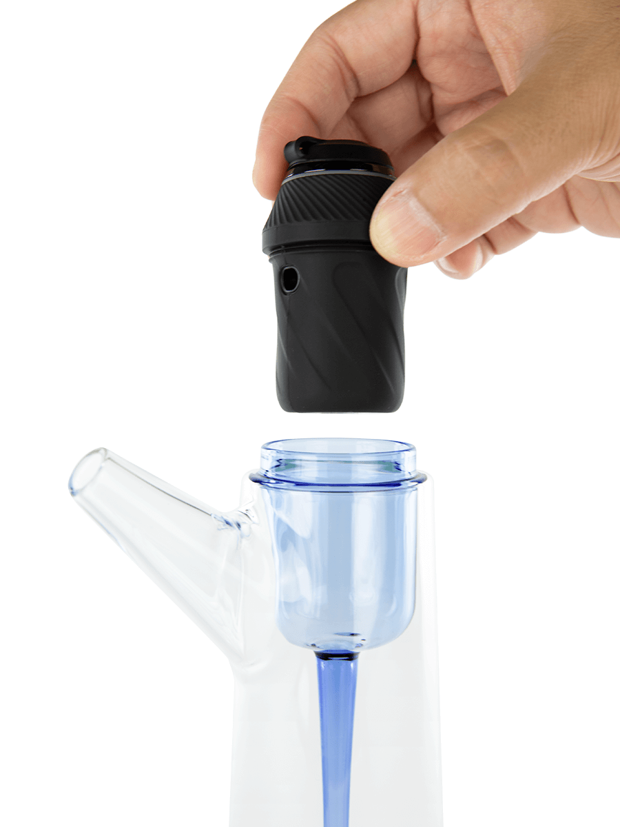 Side shot of Puffco dab water pipe with hand hovering black base over the opening